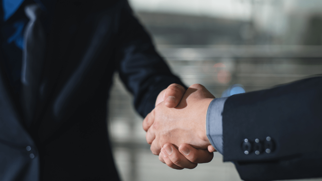 Two people handshaking as a sign of partnership