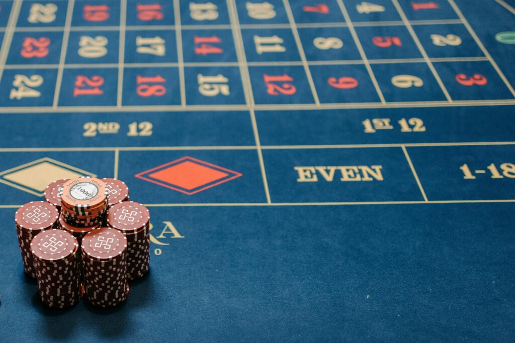 Detailed image of a roulette table with poker chips stacked, showcasing casino gaming.